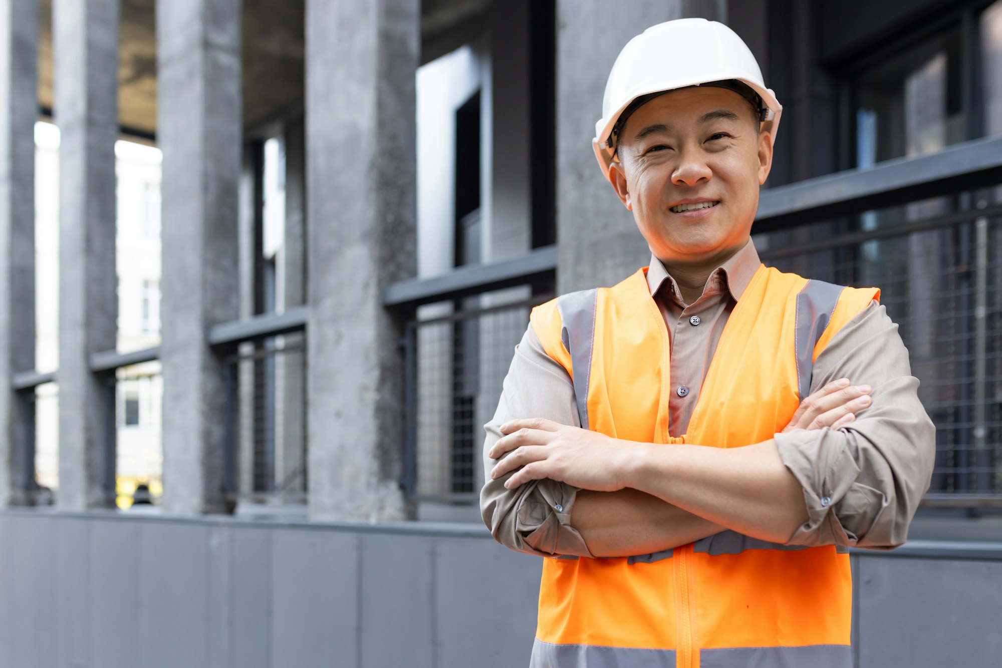 Confident construction worker smiling at a building site
